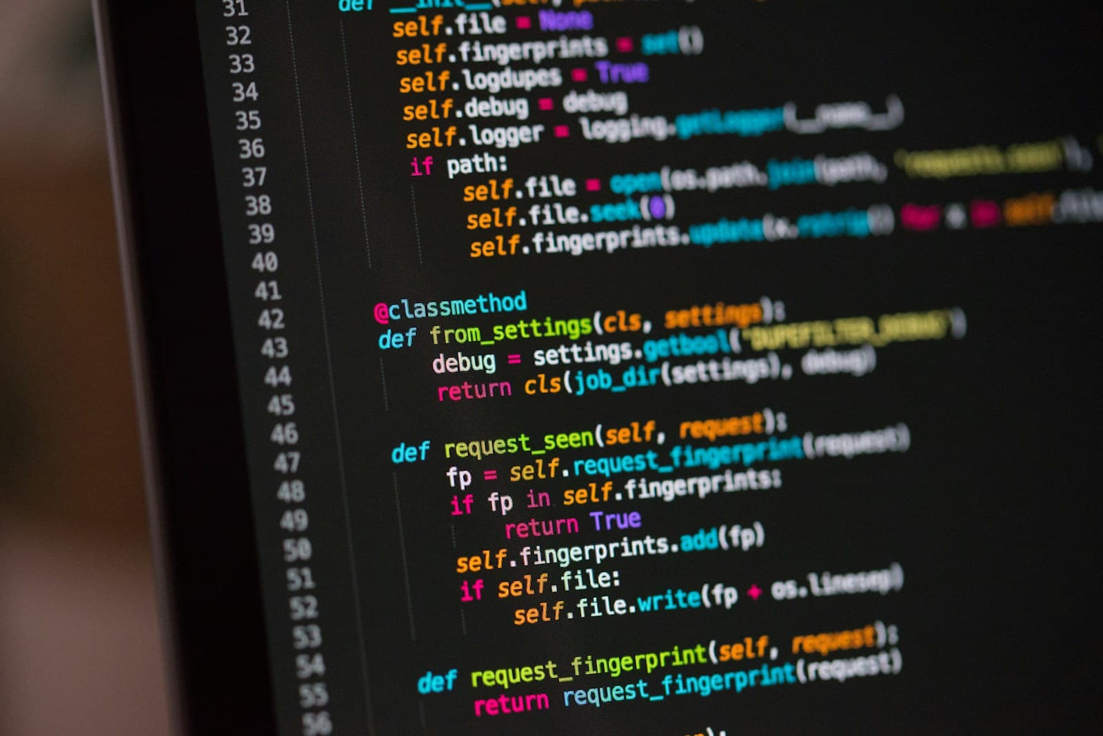 Code on a laptop in a dark development workspace